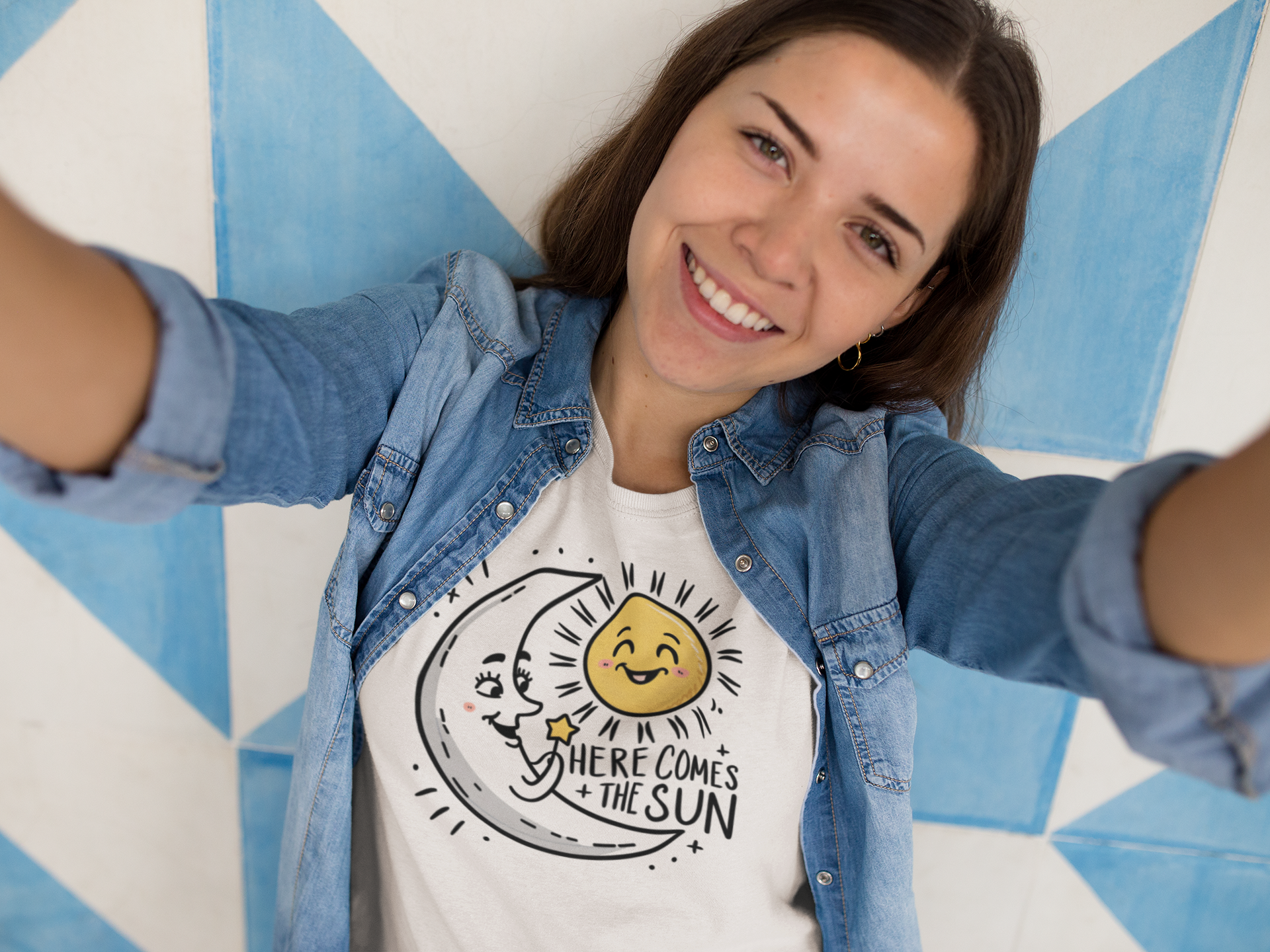 A smiling girl wearing a here come the sun t shirt as the moon welcome the sun