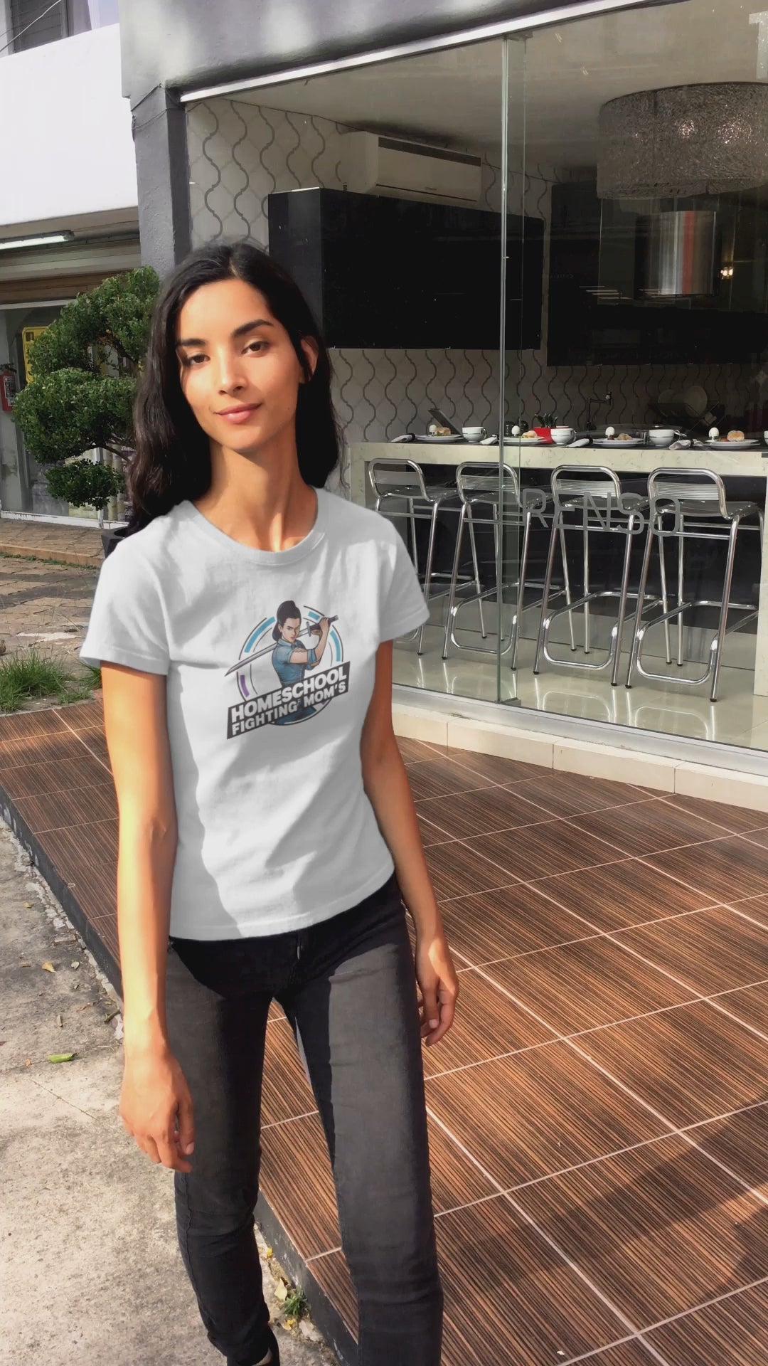 a video displaying young woman wearing a tshirt with a modern woman brandishing a sword with the logo Homeschool Fighing Mom's