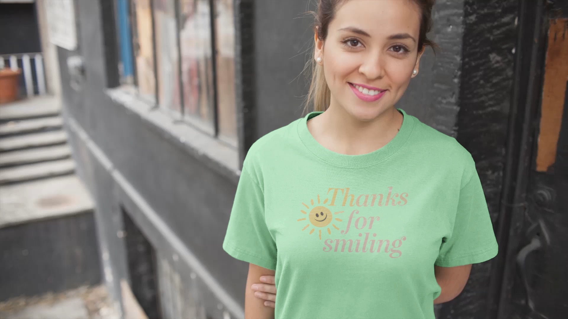 a video of a smiling girl wearing a unisex t-shirt with a smiling sun and the slogan Thanks For Smiling