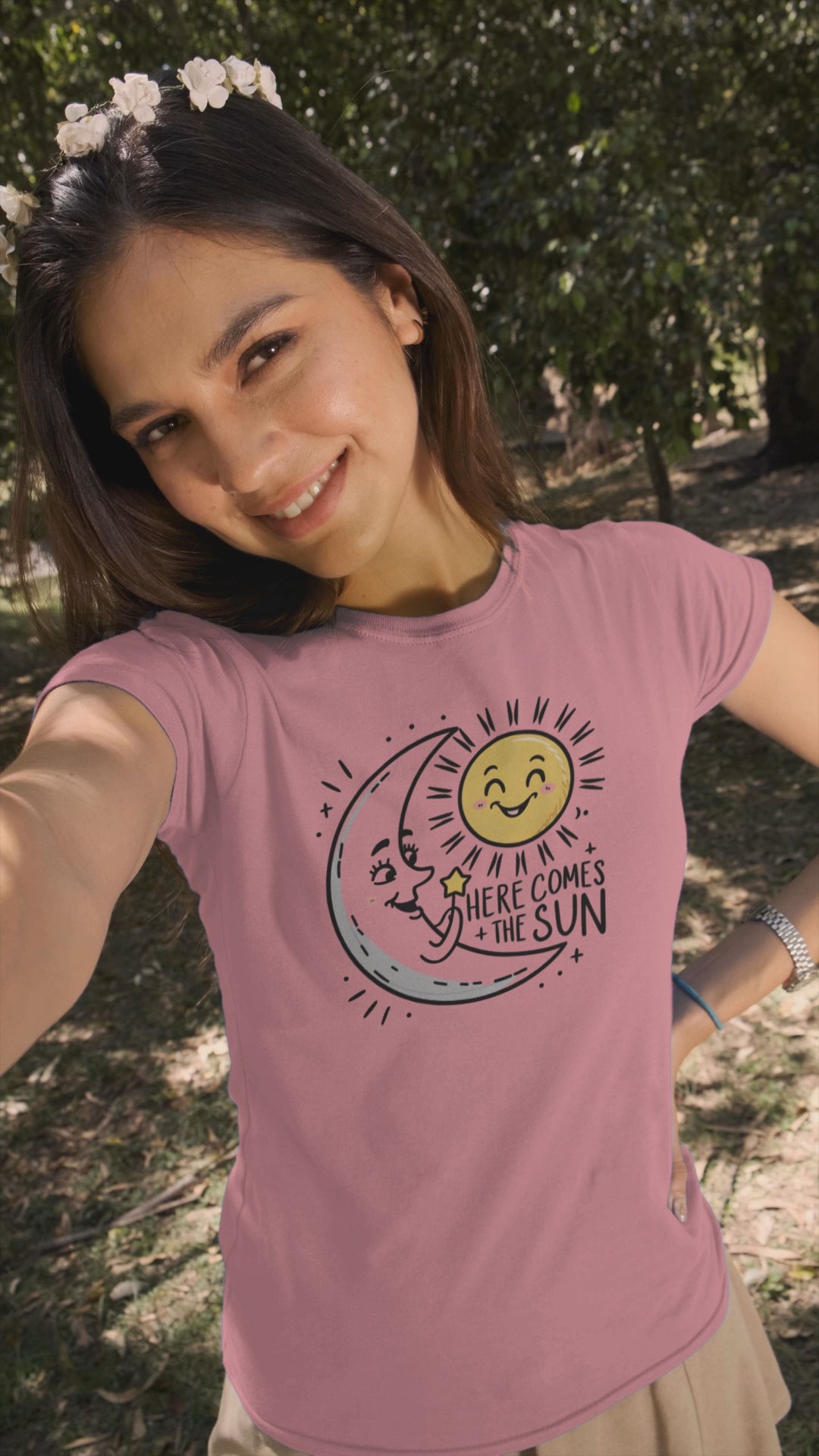 a video with a young woman wearing a t shirt of the moon greeting  the smiling sun with the caption Here Come The Sun