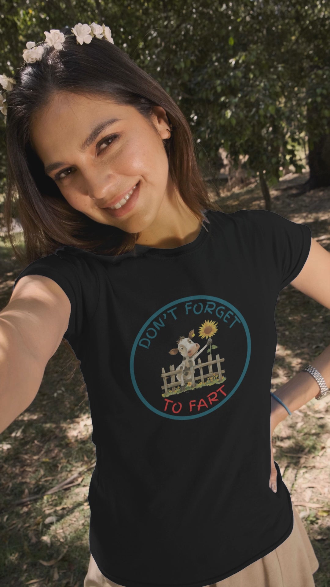 a video of woman wearing a t shirt of a cow leaning over a fence holding a flower with the funny caption Don't Forget To Fart