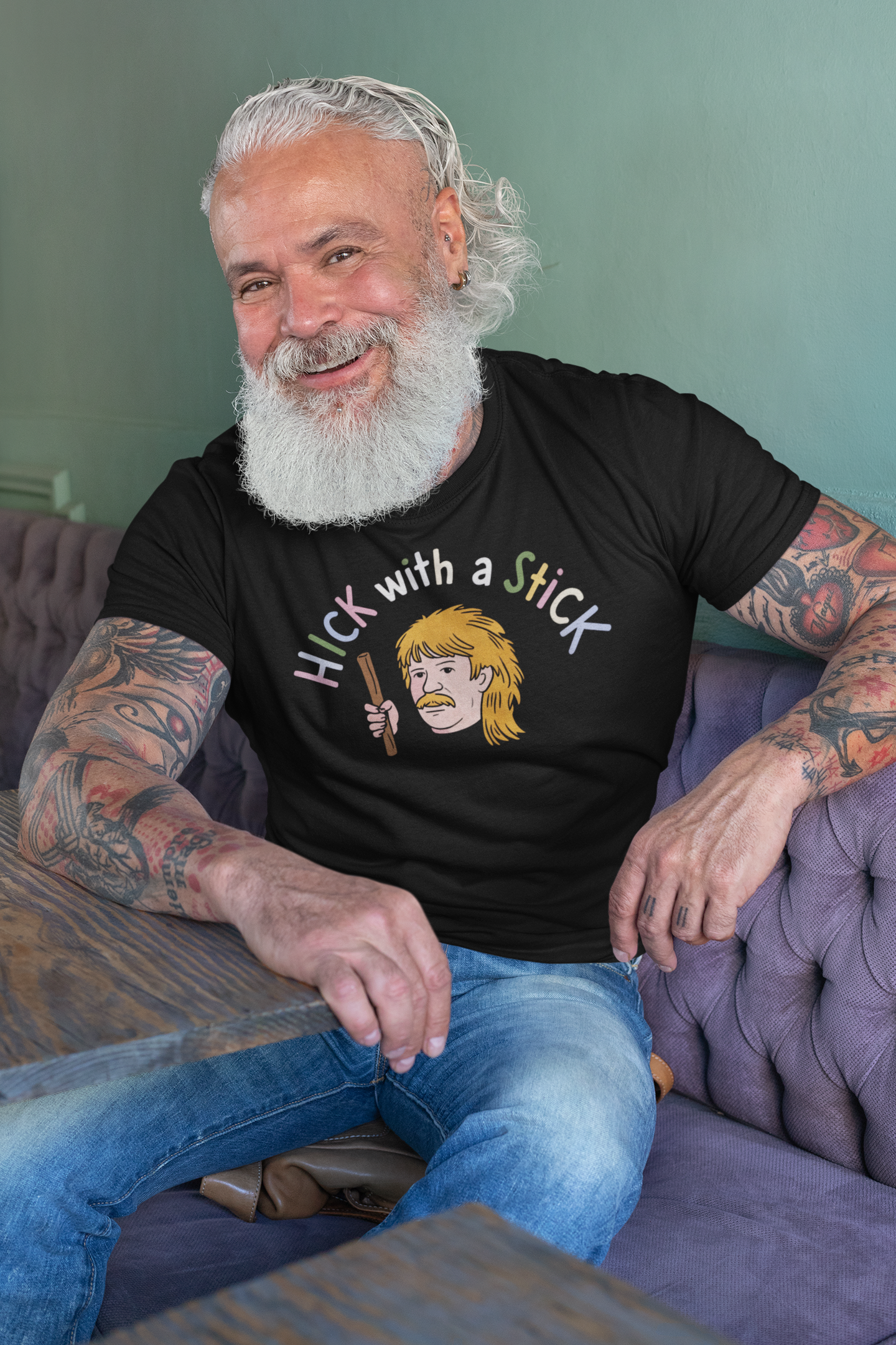 a senior man wearing a shirt with illustration of hillbilly with mullet holding a stick with the funny caption Hick with a Stick