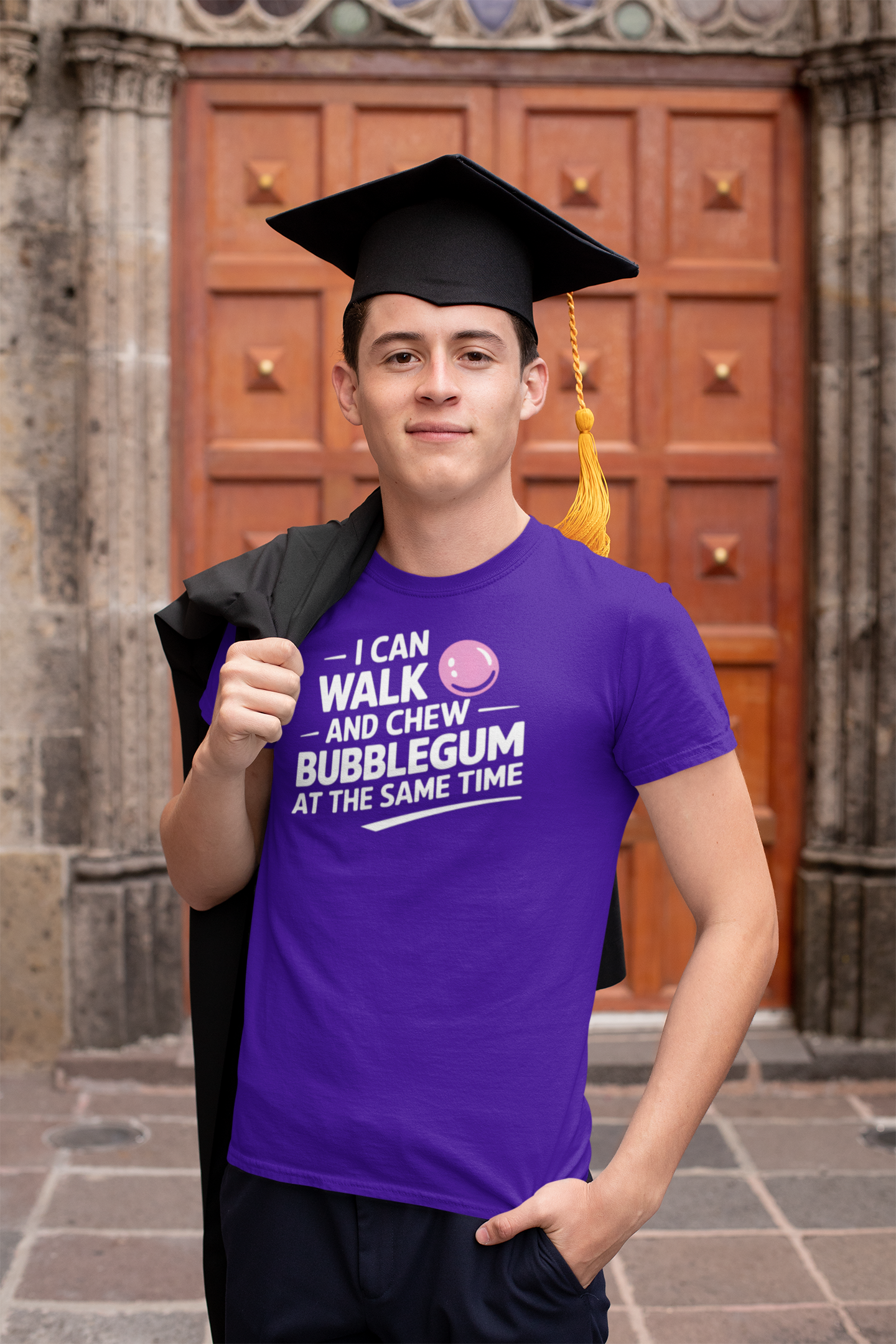 a fraduate wears a  t-shirt that reads I Can Walk And Chew Bubblegum At The Same Time. G