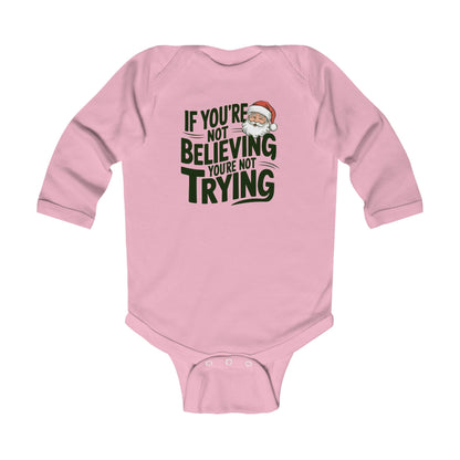 Baby in christmas onesie wearing a If you're not beieving you're not trying santa claus believer