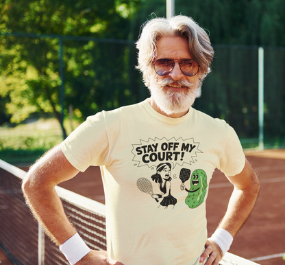a male tennis player wearing a Stay off my court funny t shirt featuring female tennis player yelling at a pickle ith a pickle raquet