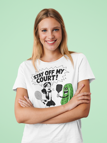 a female tennis player wearing a Stay off my court funny t shirt featuring female tennis player yelling at a pickle ith a pickle raquet