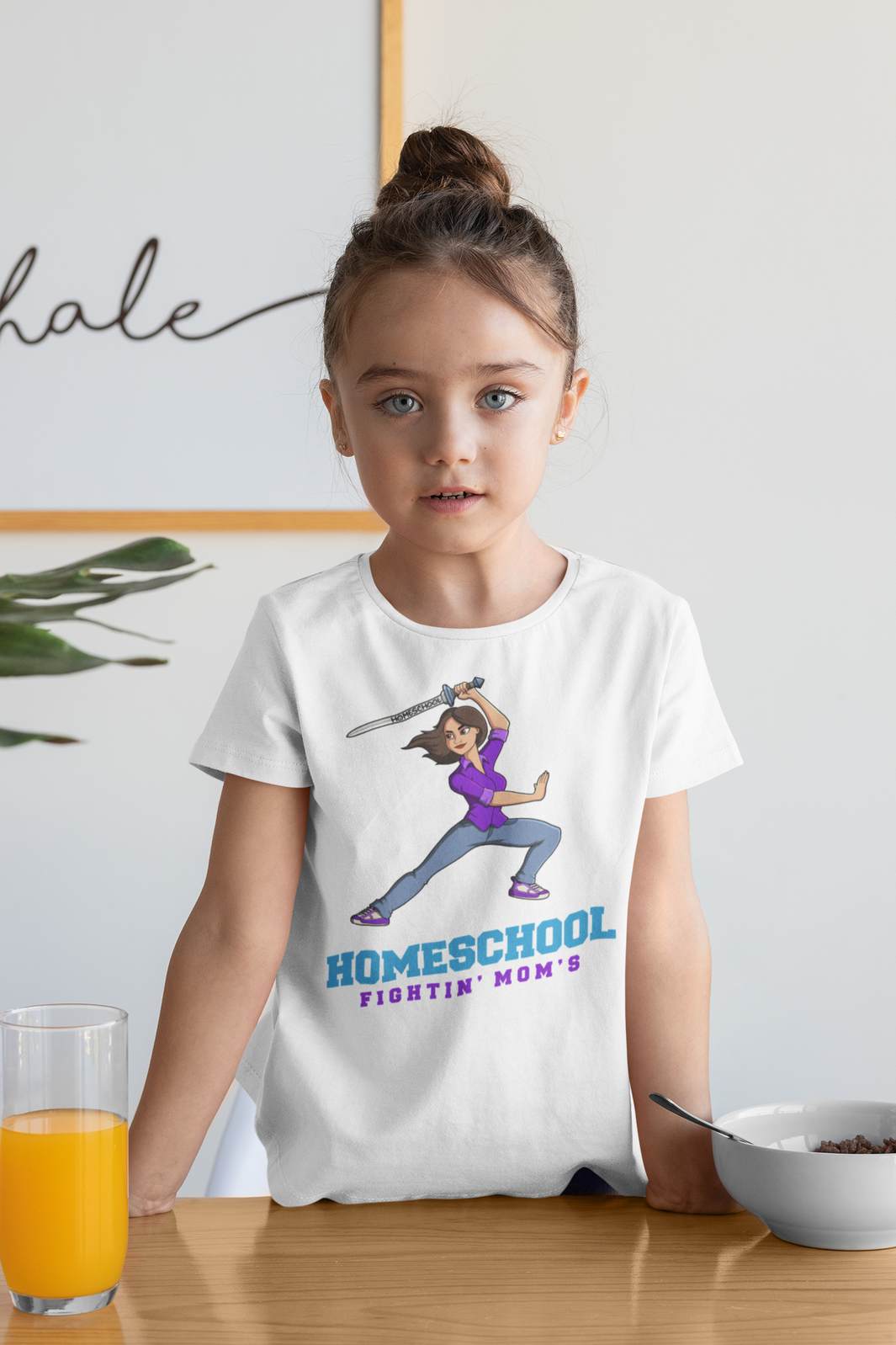 a young girl wearing a shirt with a warrior mom holding a sword reading homeschool