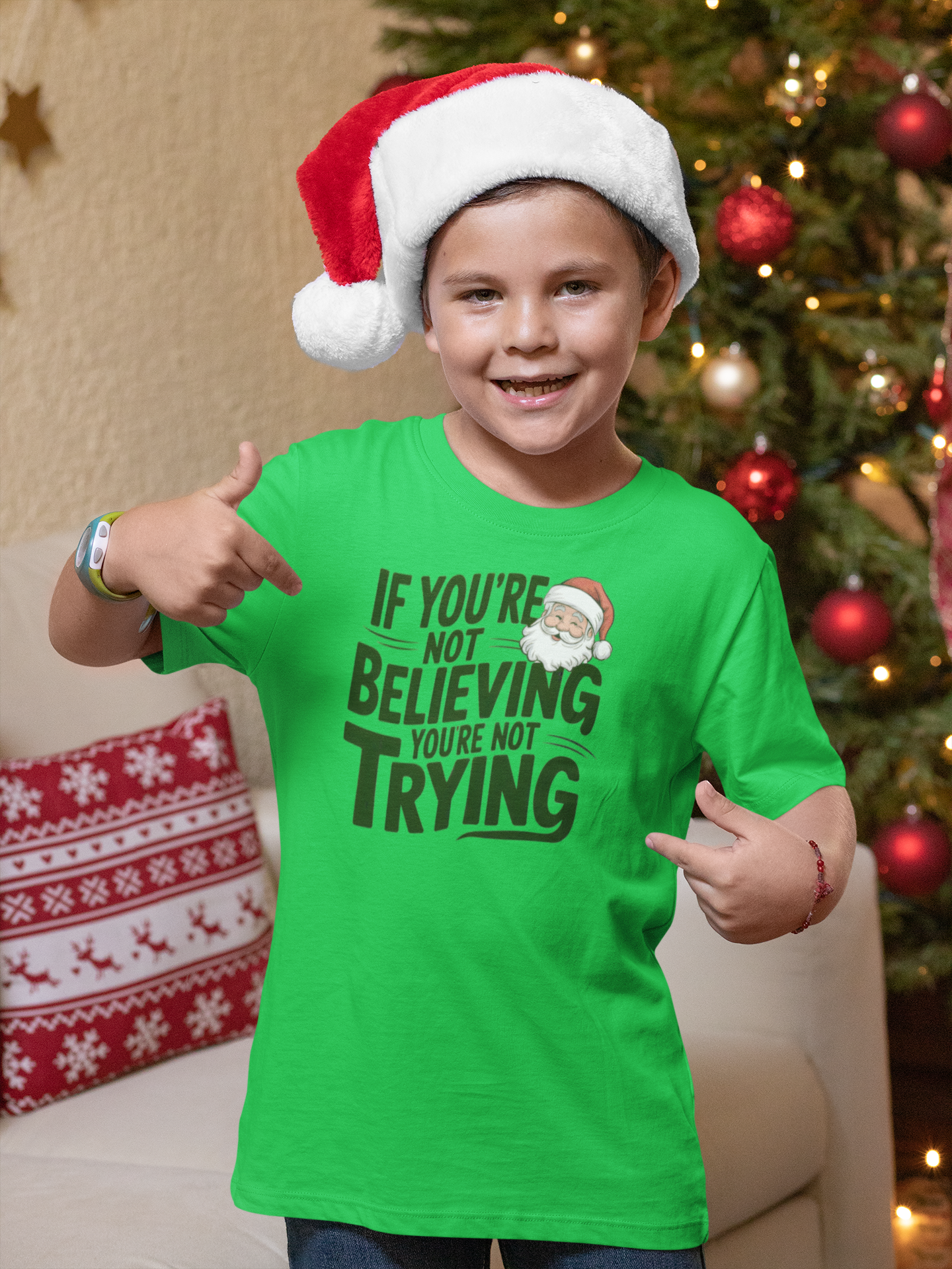 boy in christmas t-shirt wearing a If you're not beieving you're not trying gift