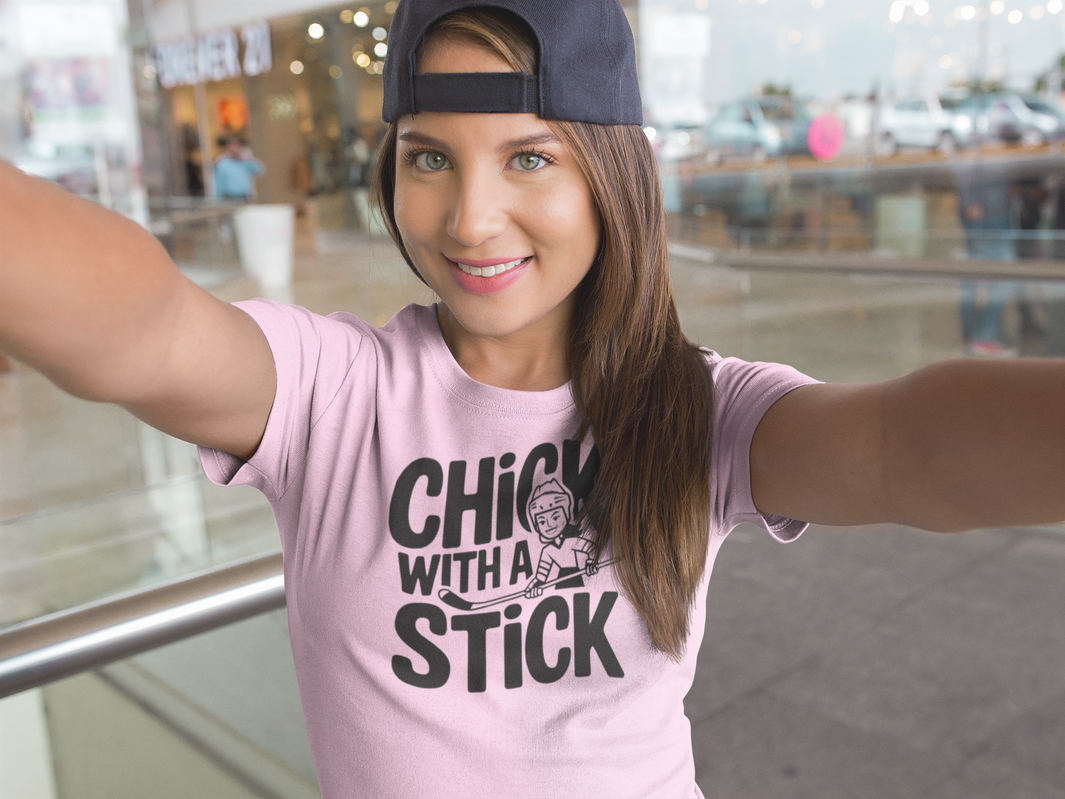 a girl wearing a t shirt of  girl holding a hockey stick with the caption Chick With A Stick