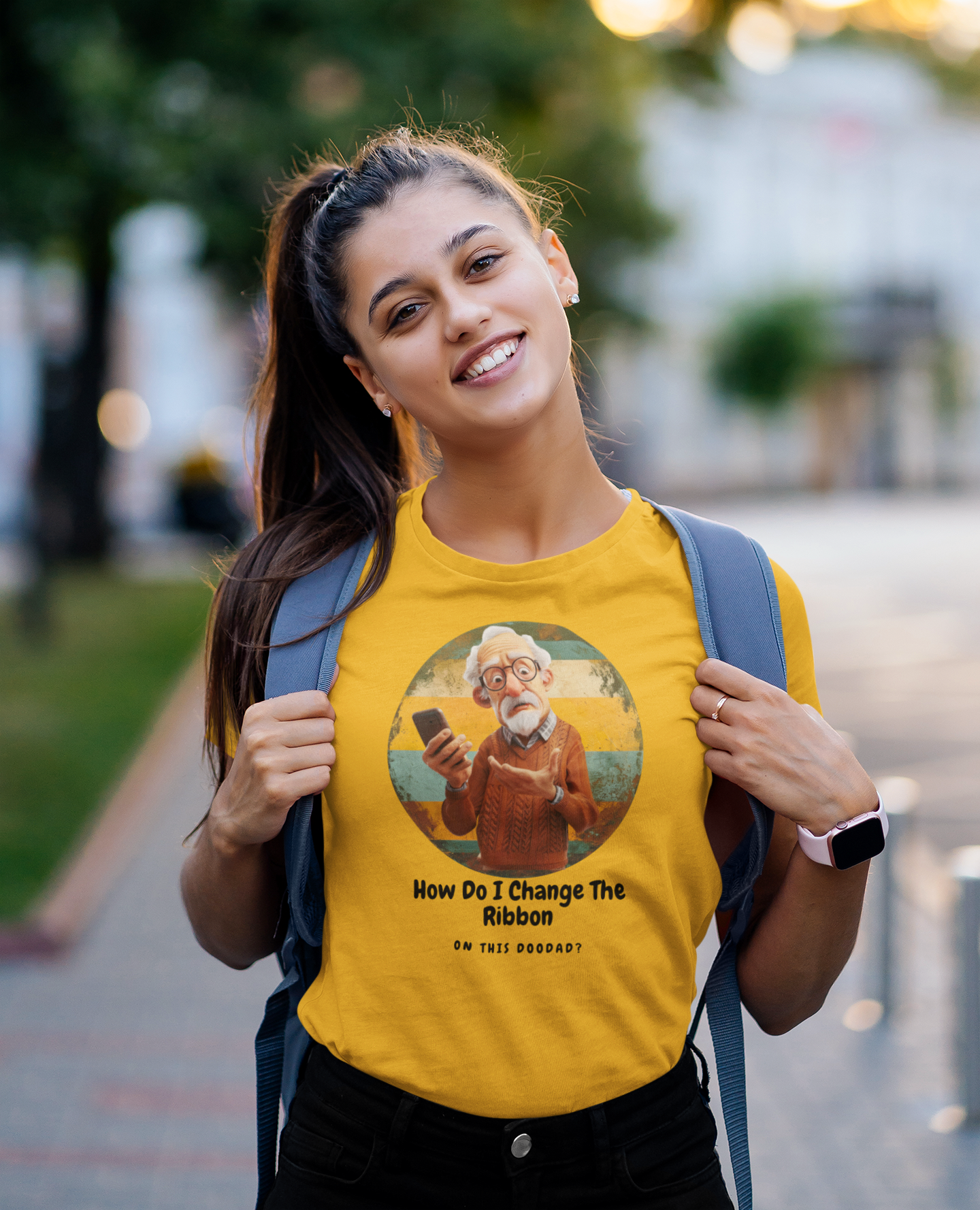 a young fun woman wearing a  t shirt of a grandpa holding a phone with the caption How Do I Change The Ribbon On this Doodad
