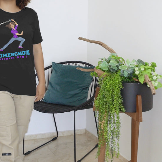 a woman in wearing a t shirt with a illustration of mom branding a sword with the slogan Homeschool Fightin' Mom'