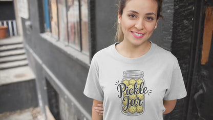 a video of a girl wearing a t-shirt with a mason jar full of pickleballs with the slogan pickle jar