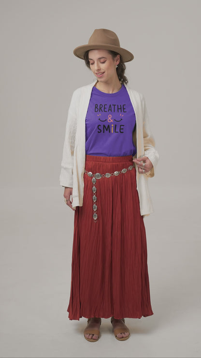 a video with a young woman wearing a t shirt with a happy face and the slogan Breathe & Smile