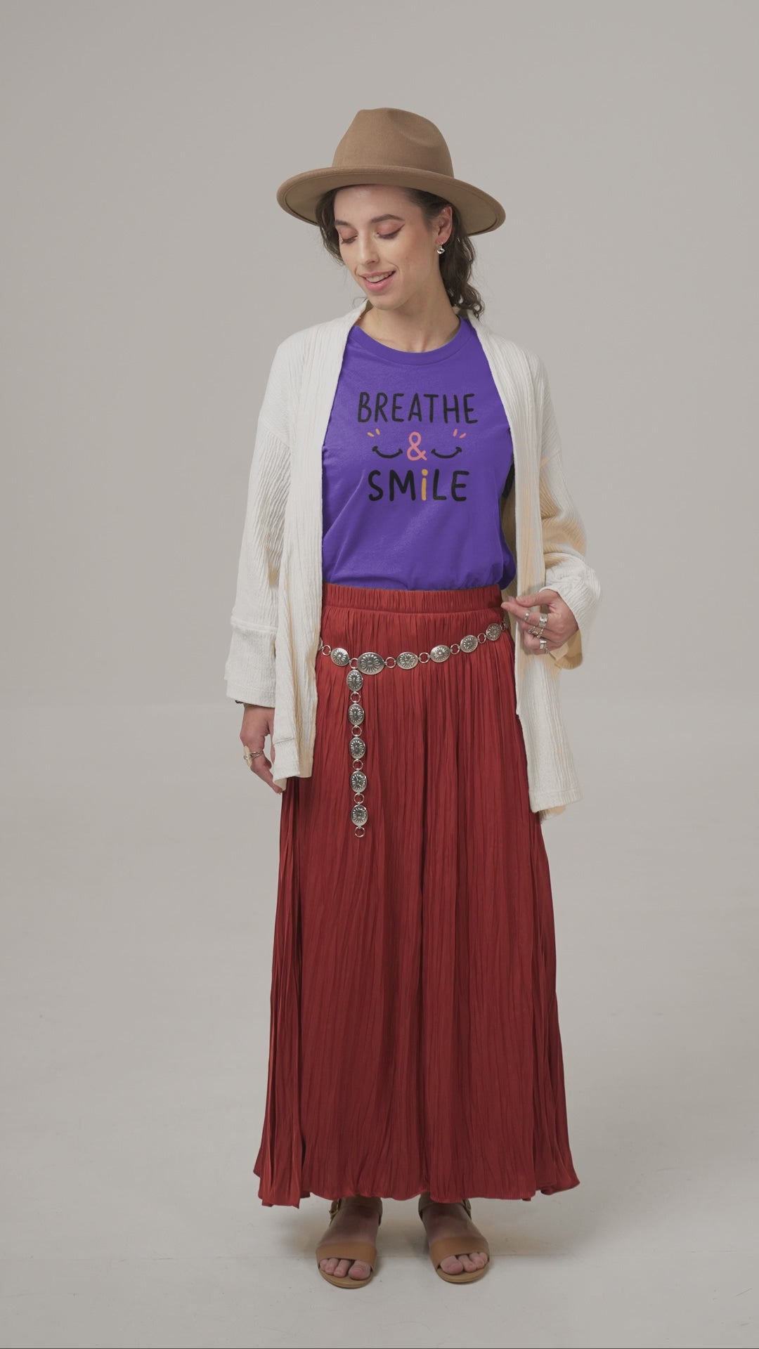 a video with a young woman wearing a t shirt with a happy face and the slogan Breathe & Smile