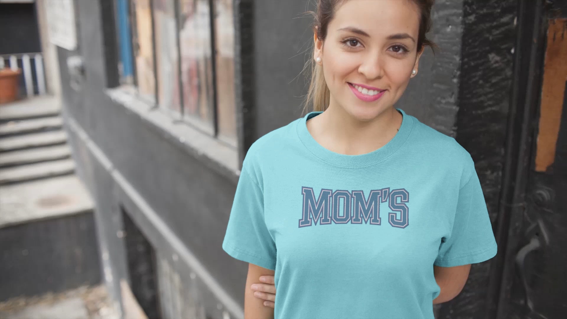 a video with young woman wearing a collegiate style logo with the caption Mom's