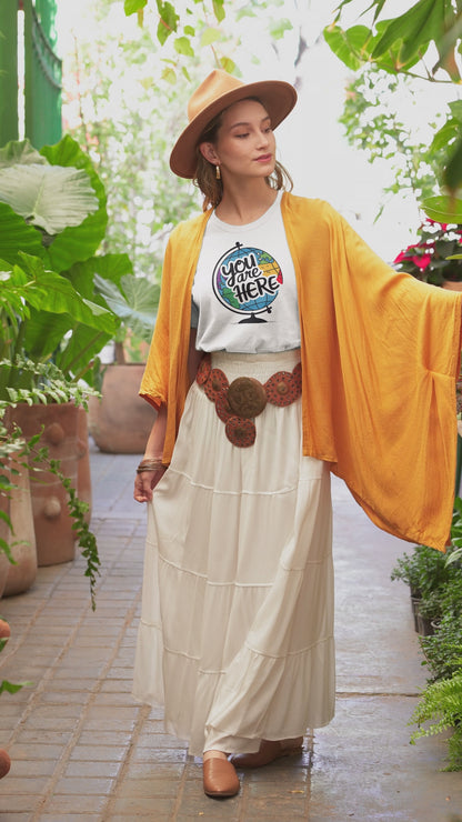a video with a woman wearing a t-shirt with a illustration of a world globe with the funny caption You Are Here