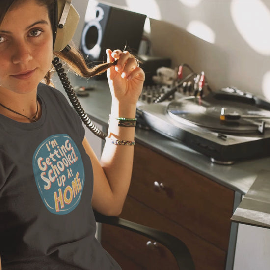 a young woman video wearing a t shirt a retro design shirt with the logo I'm Getting Schooled Up At Home 