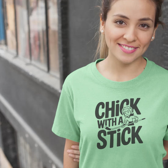 a video of woman wearing a t shirt of  girl holding a hockey stick with the caption Chick With A Stick