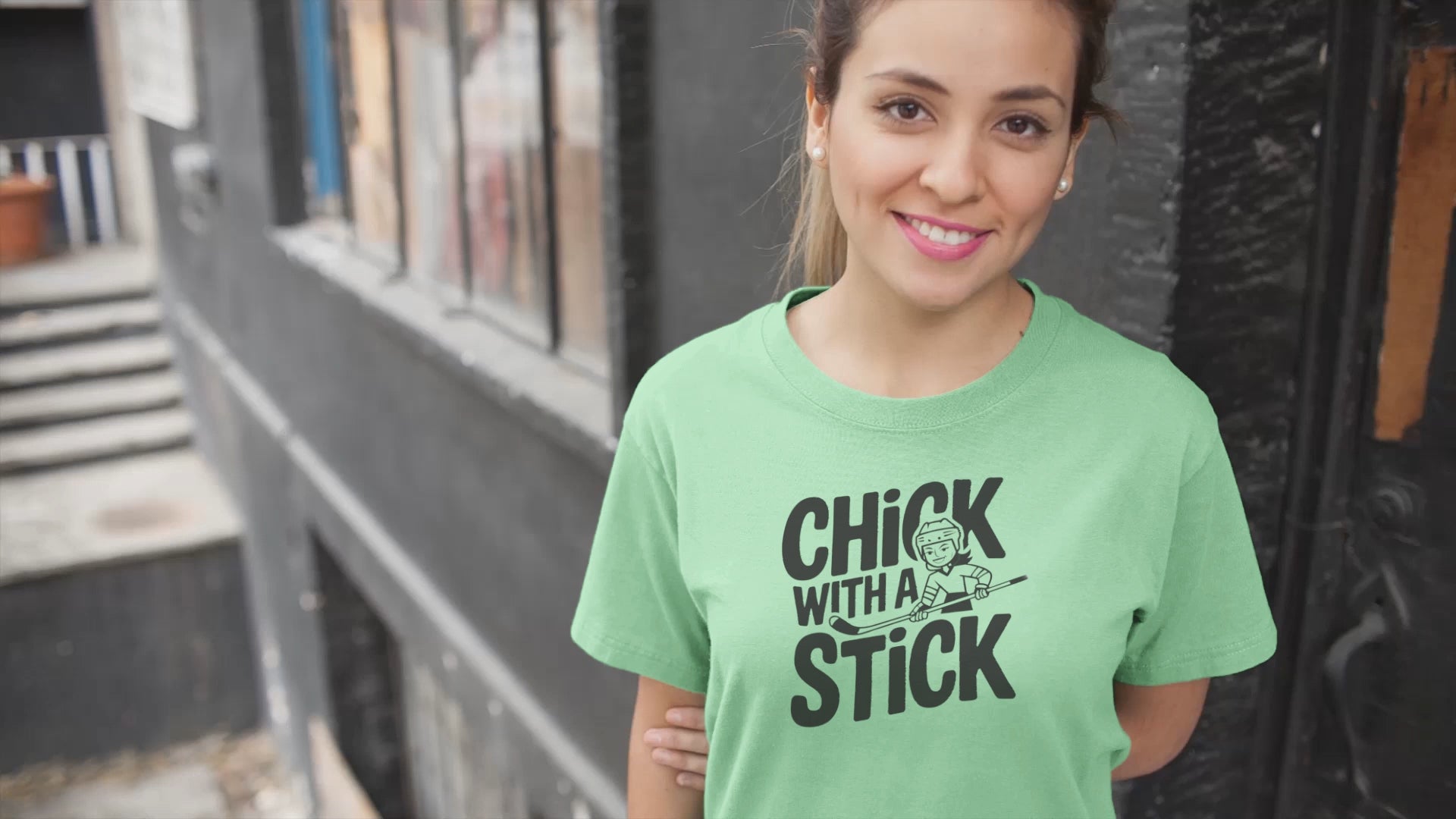 a video of woman wearing a t shirt of  girl holding a hockey stick with the caption Chick With A Stick