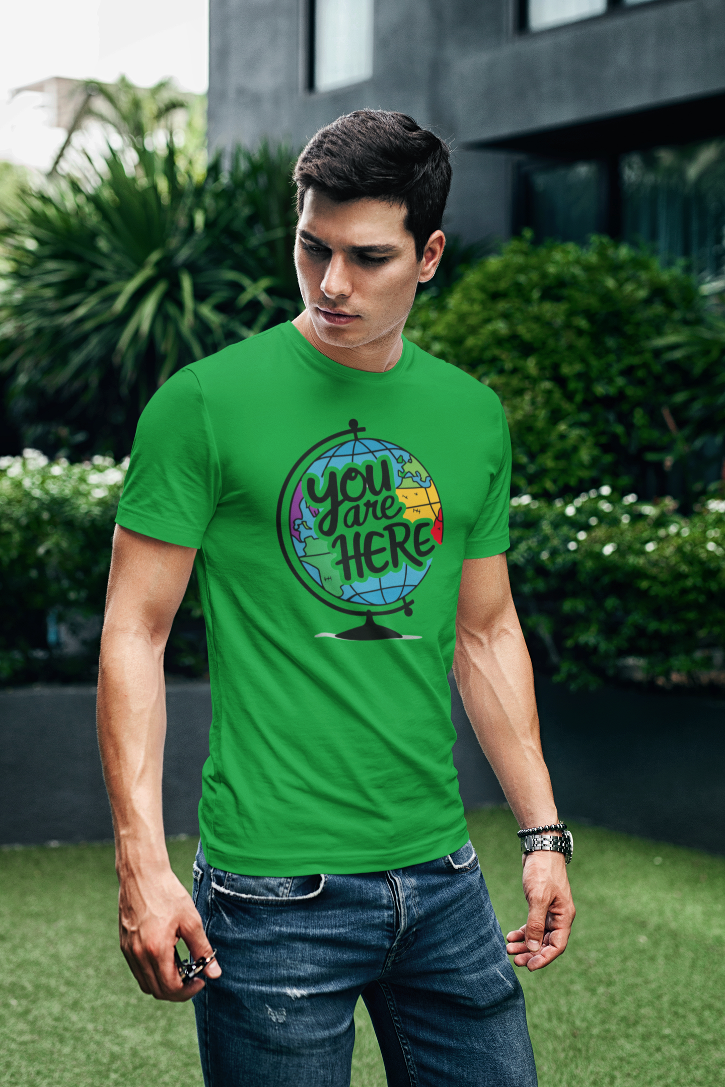 a young man wearting a t shirt with illustration of a world globe with the funny caption You Are Here