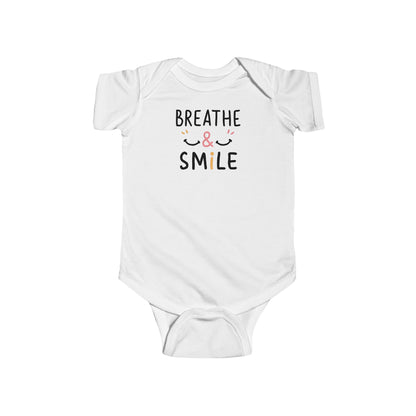 Mom holding her happy baby boy wearing a onesie with the words breathe & Smile
