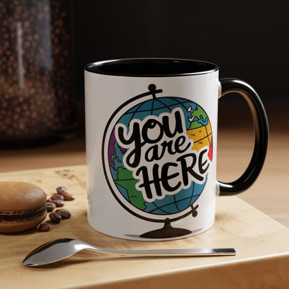 a mug with a picture of a globe with the caption you are here
